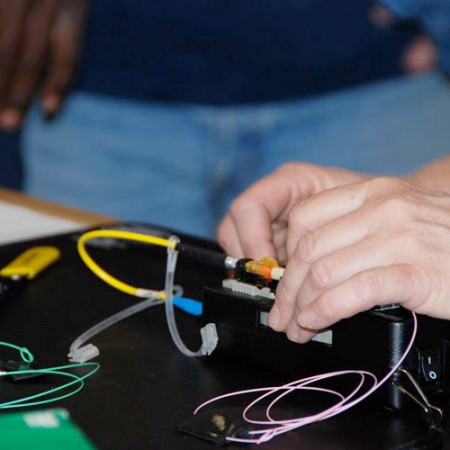 close-up of two hands connecting fibre optic cabling