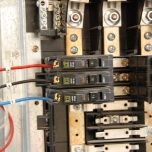 a close-up of three circuit breakers and a breaker panel