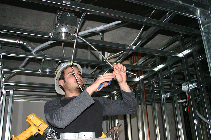 electrical worker connecting ceiling wiring