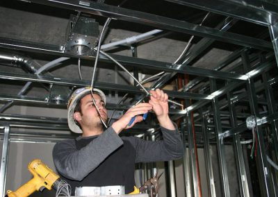 electrical worker connecting ceiling wiring