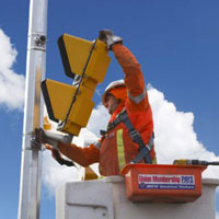worker installing pedestrian traffic signal